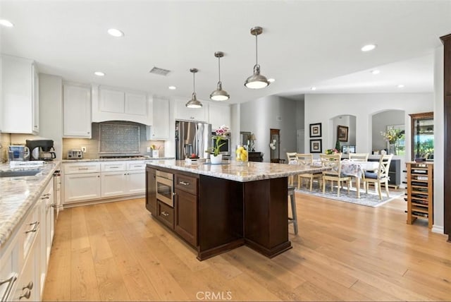 3526 Alder Pl, Chino Hills, CA 91709 - kitchen with appliances with stainless steel finishes, light wood finished floors, recessed lighting, white cabinets, and arched walkways