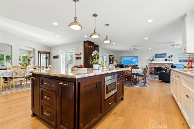 3526 Alder Pl, Chino Hills, CA 91709 - kitchen with stainless steel microwave, white cabinetry, a fireplace, dark brown cabinets, and recessed lighting