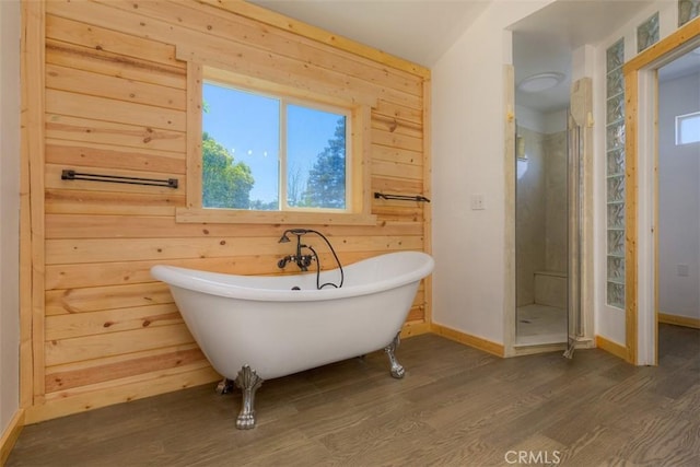 246 E Shasta St, Orland, CA 95963 - bathroom featuring wood finished floors, healthy amount of natural light, a soaking tub, a shower stall, and wood walls