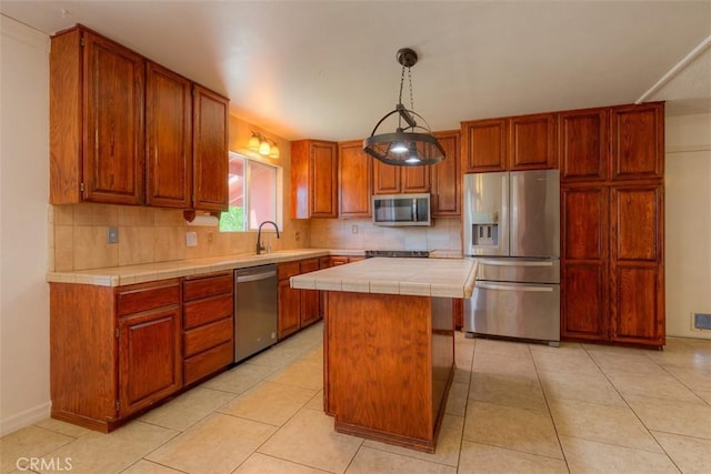 246 E Shasta St, Orland, CA 95963 - kitchen with stainless steel appliances, tile counters, a center island, tasteful backsplash, and light tile patterned floors
