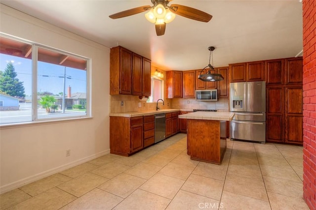 246 E Shasta St, Orland, CA 95963 - kitchen with stainless steel appliances, healthy amount of natural light, tile countertops, and a kitchen island