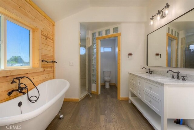 246 E Shasta St, Orland, CA 95963 - full bathroom with double vanity, a freestanding bath, vaulted ceiling, wood finished floors, and plenty of natural light