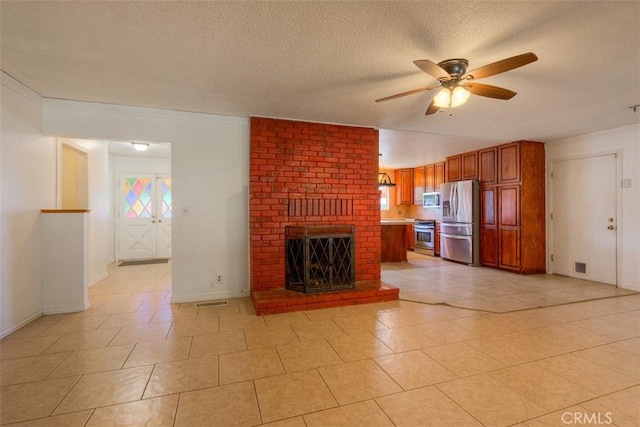 246 E Shasta St, Orland, CA 95963 - unfurnished living room with a ceiling fan, a textured ceiling, light tile patterned floors, and a fireplace