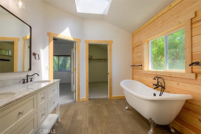 246 E Shasta St, Orland, CA 95963 - bathroom with vaulted ceiling, a skylight, wood finished floors, double vanity, and a soaking tub
