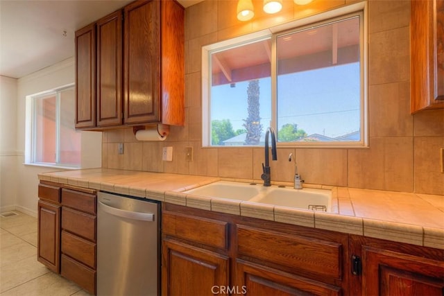 246 E Shasta St, Orland, CA 95963 - kitchen with dishwasher, brown cabinets, light tile patterned floors, and decorative backsplash