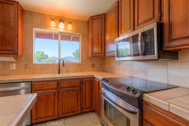 246 E Shasta St, Orland, CA 95963 - kitchen with stainless steel appliances, brown cabinets, and backsplash