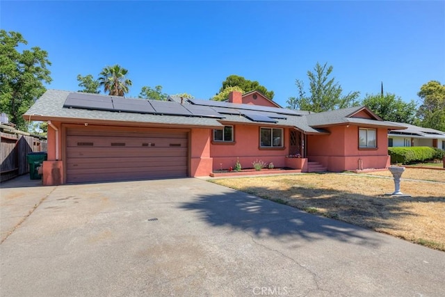 246 E Shasta St, Orland, CA 95963 - ranch-style home featuring stucco siding, solar panels, a garage, and driveway