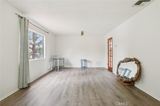 18900 Delaware St Unit 214, Huntington Beach, CA 92648 - empty room featuring wood finished floors and a textured ceiling