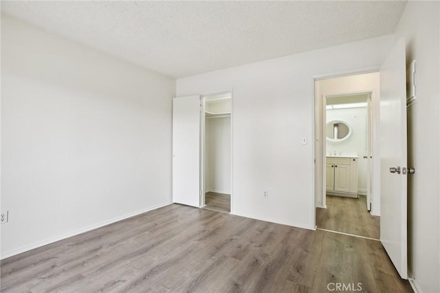 18900 Delaware St Unit 214, Huntington Beach, CA 92648 - unfurnished bedroom featuring wood finished floors, a closet, and a textured ceiling