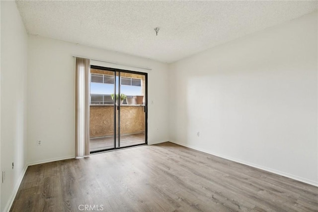 18900 Delaware St Unit 214, Huntington Beach, CA 92648 - unfurnished room featuring wood finished floors, a textured ceiling, and fire sprinkler in ceiling