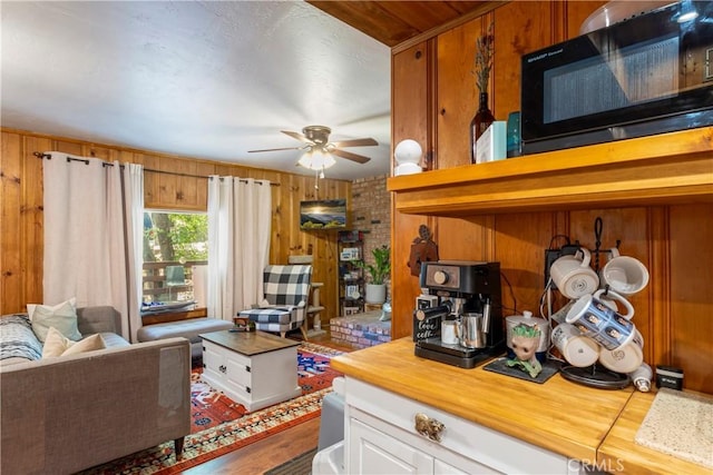 32135 W Dr, Running Springs, CA 92382 - living area with wood walls, a ceiling fan, and wood finished floors