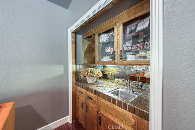 2640 Tenaya Way, Fresno, CA 93711 - bar featuring dark wood finished floors, a textured wall, and decorative backsplash