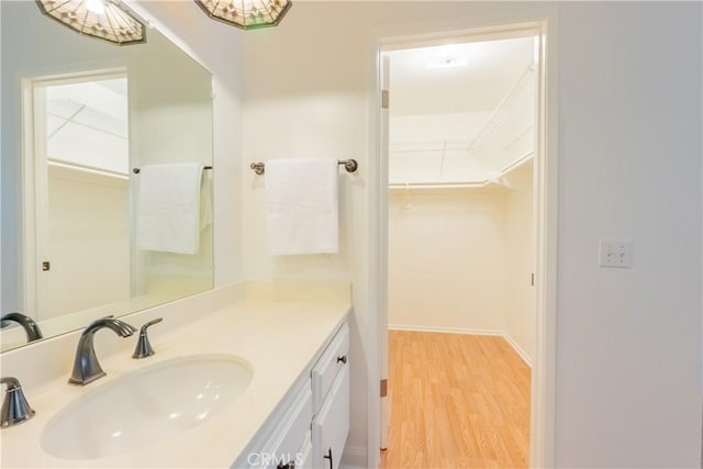 7215 Enfield Ave, Reseda, CA 91335 - bathroom featuring vanity, a walk in closet, and wood finished floors