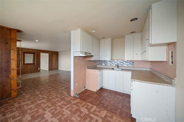 1799 Saint Thomas Ave, Cambria, CA 93428 - kitchen with under cabinet range hood, white cabinetry, recessed lighting, open floor plan, and tasteful backsplash