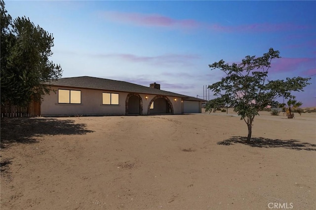 27363 Azurite Rd, Barstow, CA 92311 - view of front of home featuring an attached garage, dirt driveway, and a chimney