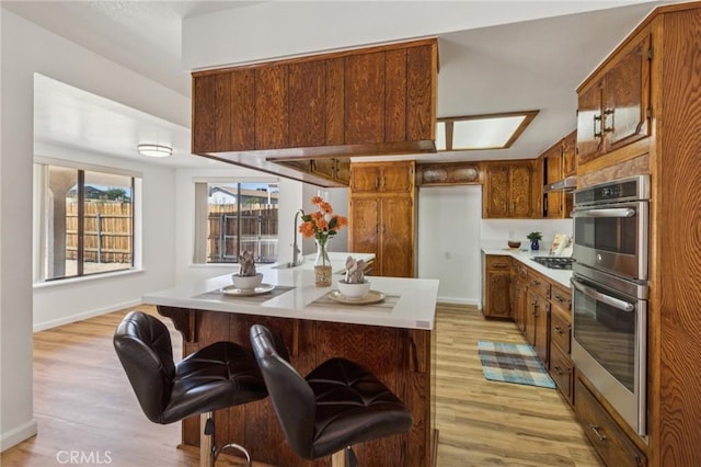 27363 Azurite Rd, Barstow, CA 92311 - kitchen featuring light wood-style floors, appliances with stainless steel finishes, and brown cabinets