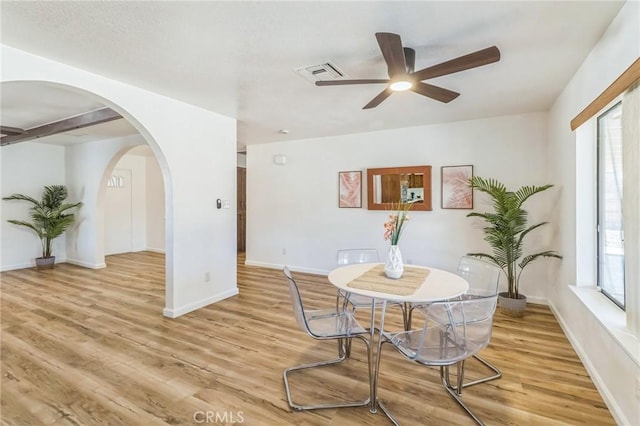 27363 Azurite Rd, Barstow, CA 92311 - dining room featuring a ceiling fan, light wood-style floors, and arched walkways