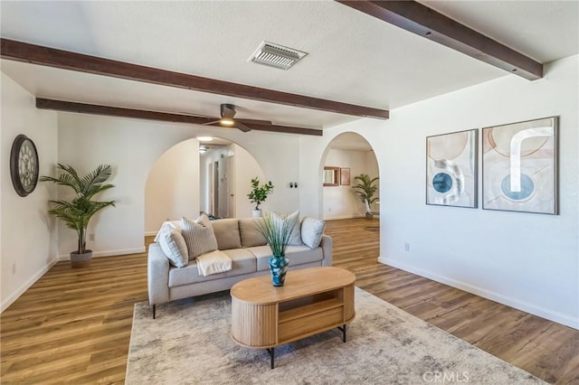 27363 Azurite Rd, Barstow, CA 92311 - living area with arched walkways, ceiling fan, wood finished floors, and beam ceiling