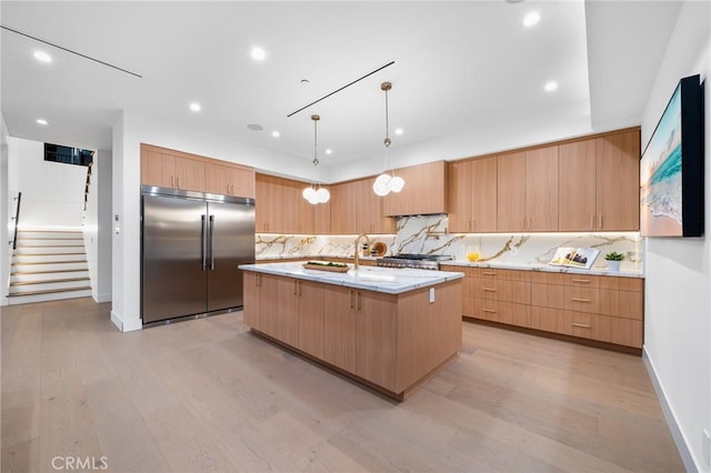 5945 Hesperia Ave, Encino, CA 91316 - kitchen with built in refrigerator, light wood-type flooring, backsplash, an island with sink, and recessed lighting