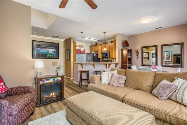 93 Kansas St Unit 205, Redlands, CA 92373 - living area featuring light wood-style flooring, a ceiling fan, and a glass covered fireplace