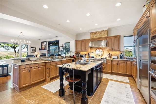 33260 Susan Grace Ct, Temecula, CA 92592 - kitchen featuring wall chimney range hood, a center island, tasteful backsplash, a peninsula, and crown molding