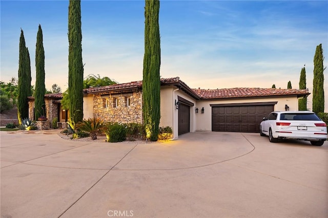 33260 Susan Grace Ct, Temecula, CA 92592 - mediterranean / spanish-style house with an attached garage, concrete driveway, stucco siding, stone siding, and a tile roof