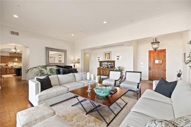 33260 Susan Grace Ct, Temecula, CA 92592 - living area with arched walkways, a chandelier, recessed lighting, crown molding, and light wood-style flooring