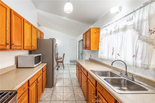 9780 Almeria Ave, Fontana, CA 92335 - kitchen featuring appliances with stainless steel finishes, lofted ceiling, brown cabinetry, light countertops, and light tile patterned flooring