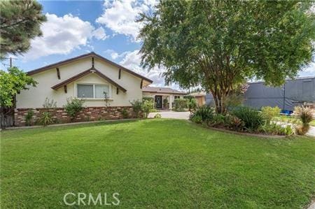 7922 Ducor Ave, West Hills, CA 91304 - rear view of house featuring a lawn, stucco siding, and brick siding