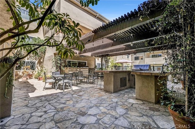1203 N Sweetzer Ave Unit 215, West Hollywood, CA 90069 - view of patio with a bar, outdoor dining space, a pergola, and an outdoor kitchen