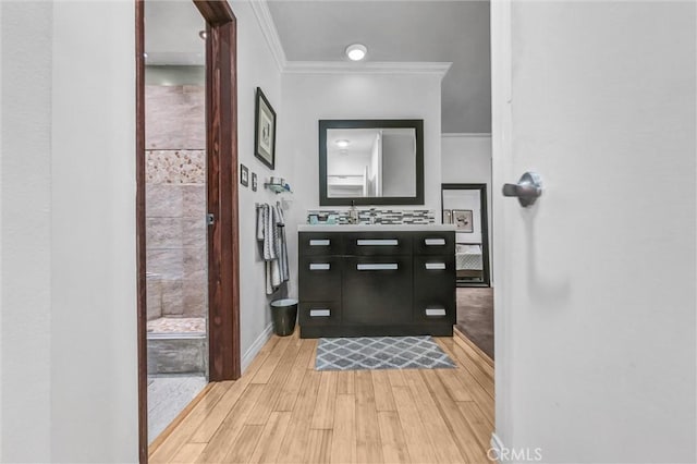 1203 N Sweetzer Ave Unit 215, West Hollywood, CA 90069 - bathroom with vanity, crown molding, wood finished floors, and tasteful backsplash