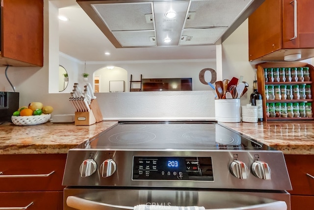12200 Montecito Rd Unit C103, Seal Beach, CA 90740 - kitchen view of stainless steel range with electric stovetop, ornamental molding, brown cabinetry, and arched walkways