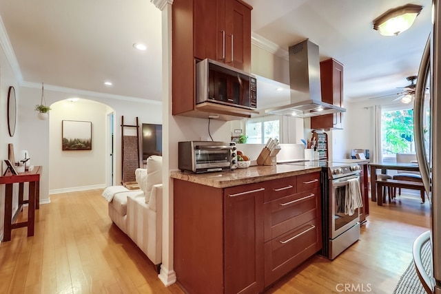 12200 Montecito Rd Unit C103, Seal Beach, CA 90740 - kitchen featuring stainless steel appliances, wall chimney range hood, a ceiling fan, light wood-style flooring, and plenty of natural light