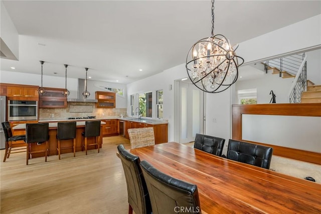 426 Nyes Pl, Laguna Beach, CA 92651 - dining area with healthy amount of natural light, light wood-style flooring, recessed lighting, a chandelier, and stairs
