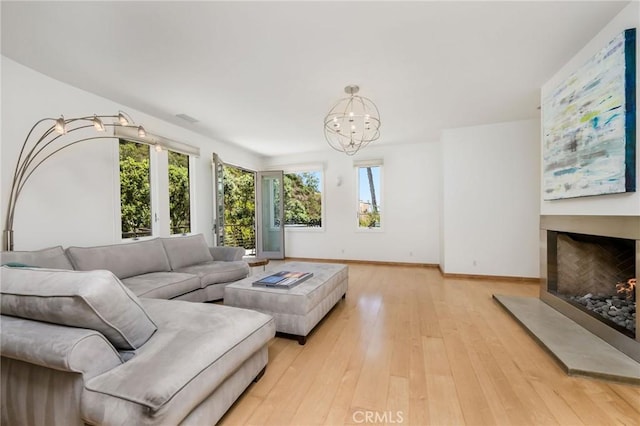 426 Nyes Pl, Laguna Beach, CA 92651 - living area featuring a chandelier, a fireplace with raised hearth, and light wood-style floors