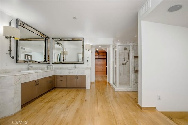 426 Nyes Pl, Laguna Beach, CA 92651 - bathroom with a stall shower, wood finished floors, double vanity, and recessed lighting