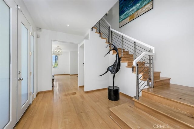 426 Nyes Pl, Laguna Beach, CA 92651 - foyer entrance with stairway, a chandelier, and wood-type flooring
