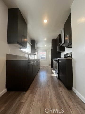 401 W Harvard St, Glendale, CA 91204 - kitchen with electric stove, wood finished floors, dark cabinetry, recessed lighting, and wall chimney range hood