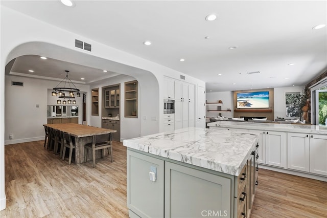 1 Tularosa Ct, Aliso Viejo, CA 92656 - kitchen featuring stainless steel microwave, arched walkways, recessed lighting, a center island, and light wood-style floors