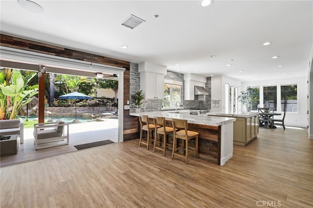 1 Tularosa Ct, Aliso Viejo, CA 92656 - kitchen featuring a peninsula, plenty of natural light, wall chimney range hood, light wood-style flooring, and recessed lighting