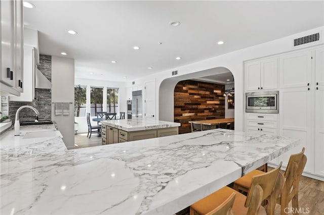 1 Tularosa Ct, Aliso Viejo, CA 92656 - kitchen featuring built in appliances, arched walkways, backsplash, recessed lighting, and a kitchen island