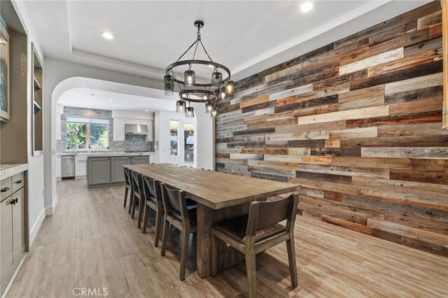 1 Tularosa Ct, Aliso Viejo, CA 92656 - dining space featuring wooden walls, recessed lighting, arched walkways, light wood finished floors, and a chandelier