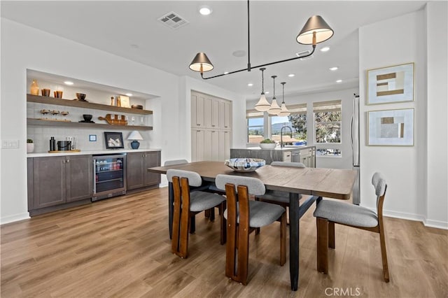 1080 Foothill Blvd, Claremont, CA 91711 - dining area with beverage cooler, a bar, recessed lighting, and light wood-type flooring