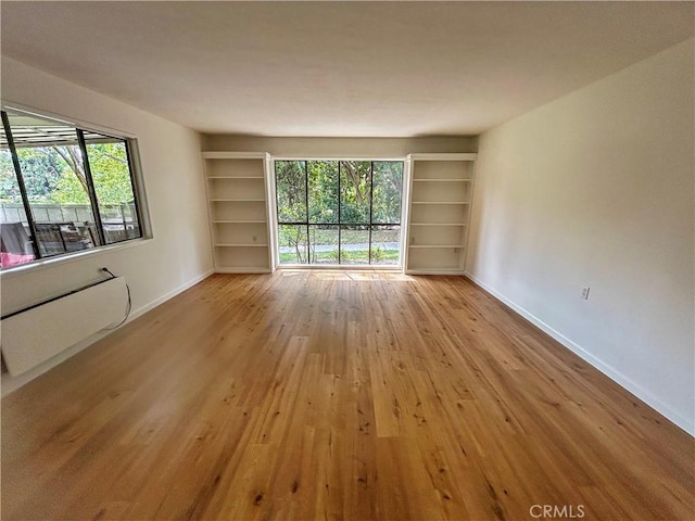 911 Ronda Sevilla Unit D, Laguna Woods, CA 92637 - empty room featuring light wood-style flooring and built in shelves