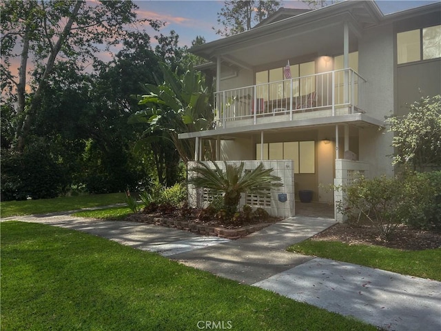911 Ronda Sevilla Unit D, Laguna Woods, CA 92637 - view of front of house with stucco siding, a balcony, and a front lawn