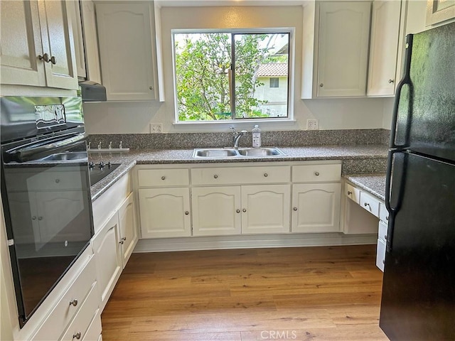 911 Ronda Sevilla Unit D, Laguna Woods, CA 92637 - kitchen with black appliances, light wood-type flooring, and white cabinetry
