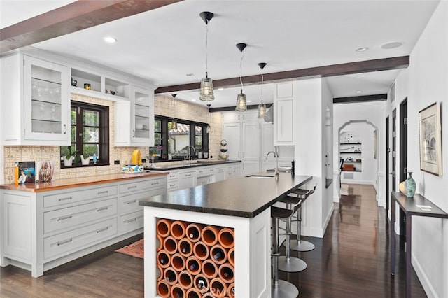282 Argonne Ave, Long Beach, CA 90803 - kitchen featuring dark wood-style flooring, decorative backsplash, beamed ceiling, a kitchen bar, and white cabinets