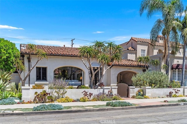 282 Argonne Ave, Long Beach, CA 90803 - mediterranean / spanish-style home featuring stucco siding, a fenced front yard, a tiled roof, and a gate