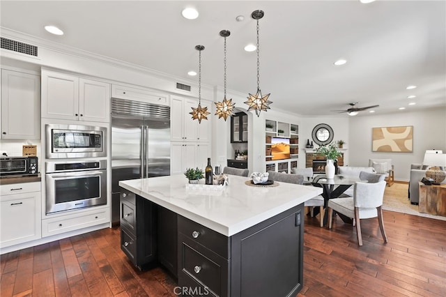 11 Heartwood Way, Aliso Viejo, CA 92656 - kitchen with built in appliances, open floor plan, crown molding, dark wood finished floors, and white cabinets