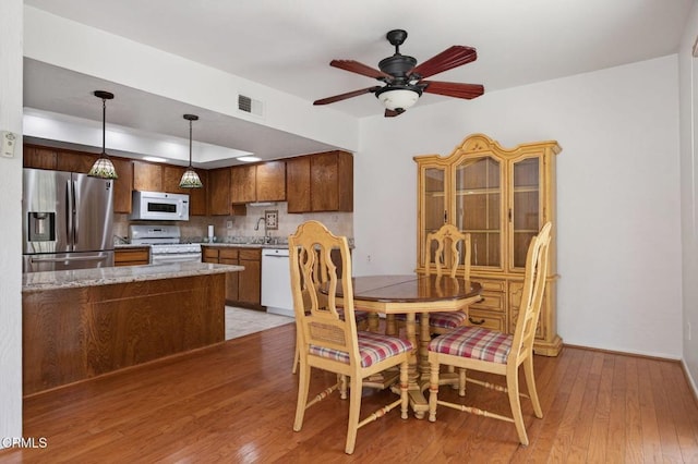 27127 Rio Bosque Dr, Valencia, CA 91354 - dining room with light wood-type flooring, ceiling fan, and a tray ceiling